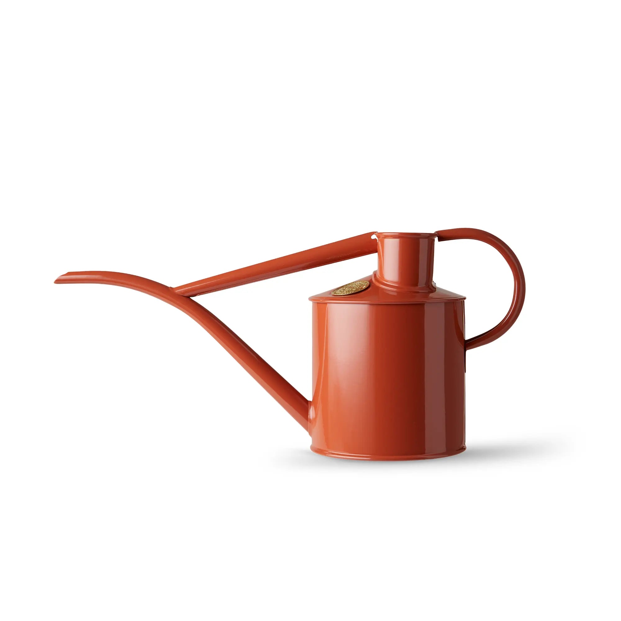 A terracotta-colored Haws Fazeley Flow metal watering can with a long spout, curved for precision watering, on a white background.