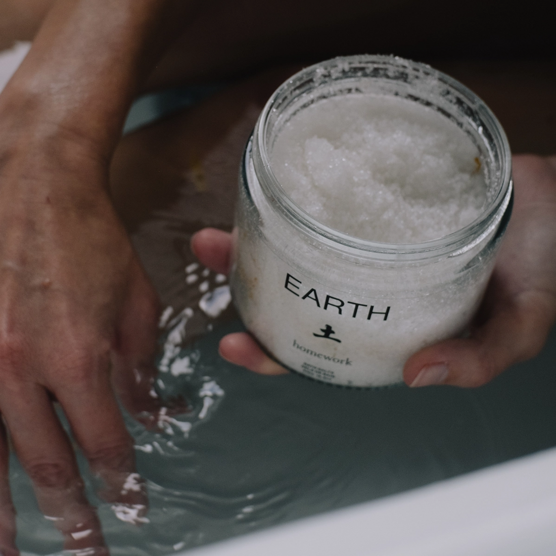 Person holding a jar of Bath Salts made by Homework labeled &
